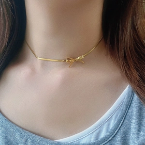 Elegant 18K gold-plated bow choker necklace shown on neck with sleek snake chain design