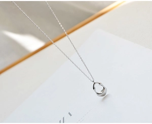 Close-up of a silver irregular hollow teardrop pendant with high polish finish