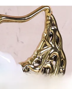 Gros plan détaillé des motifs métalliques dorés ajourés sur le vase en céramique blanche