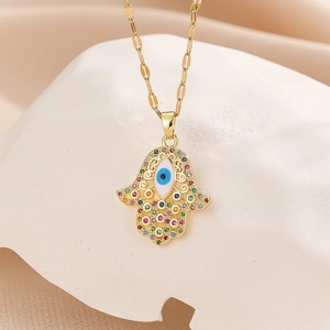 Macro shot of gold Hamsa hand necklace with colorful zircon evil eye pendant details