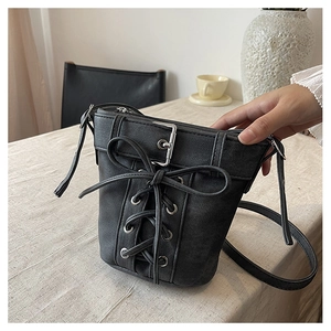 Détail du sac seau noir avec laçage style corset et boucle argentée décorative
