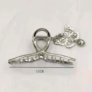 Detailed view of an 11cm silver metal hair claw clip with butterfly and heart charms