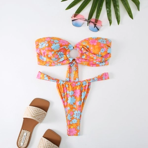 Close-up of floral print bikini with metal ring detail and tropical beach accessories