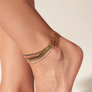 Minimalist gold anklet set with colorful zircon stones on female model ankle
