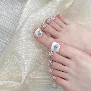 White press-on toenails with sparkling crystals and heart rhinestones on gold silk