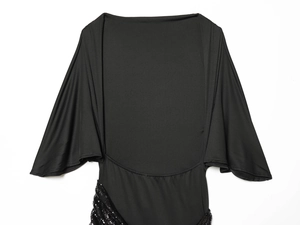 Detail of black midi dress with wide batwing sleeves and shimmering sequin belt accents