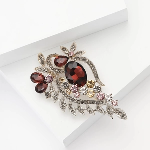 Vintage red rhinestone brooch with floral crystal design on elegant white display