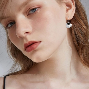 Cute black cat in coffee cup silver hook earrings shown on model for a stylish look