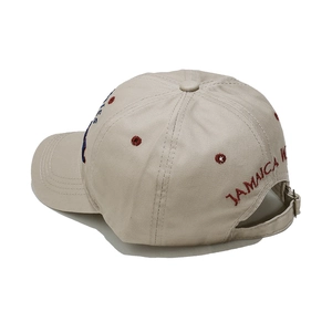 Detail of adjustable metal buckle and red Jamaica embroidery on beige cotton baseball cap