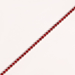 Close-up of red round-cut cubic zirconia stones set in a silver claw chain bracelet