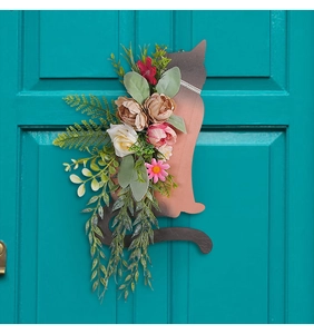 Close-up of cat-shaped wall decor with colorful faux peonies and roses on a blue wood door