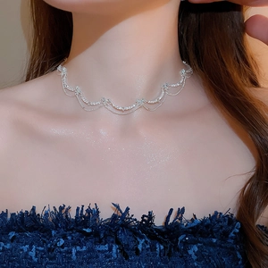 Close-up of elegant zircon butterfly layered choker necklace on woman's collarbone