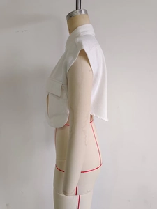 Détail du gilet blanc court en denim avec grandes poches à rabat et col montant élégant