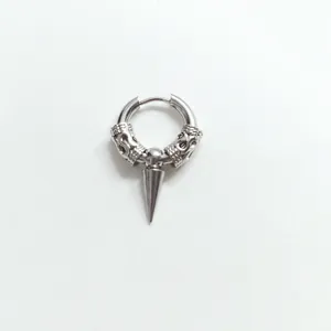 Macro shot of punk style silver hoop earring featuring a sharp metal cone pendant