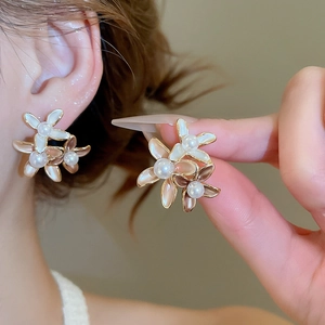 Detail of 18K gold plated flower stud earrings with enamel petals and white pearls