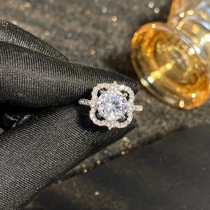 Detail van een zilveren bloemenring met ronde diamant en glanzende pavé-zetting
