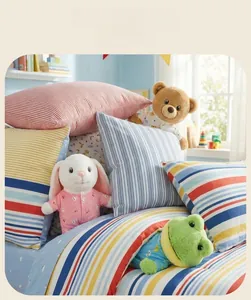 Close-up of cute plush animal toys on colorful striped bedding in a cozy nursery setting