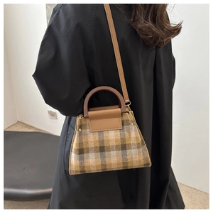 Détail d'un sac à main vintage en laine à carreaux avec garniture en cuir et bandoulière