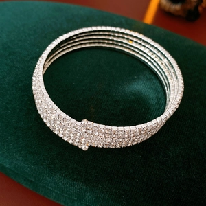 Macro view of a luxurious multi-layer silver rhinestone stretch bracelet on green velvet