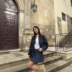Completo in denim blu scuro alla moda con giacca corta e minigonna a pieghe da donna