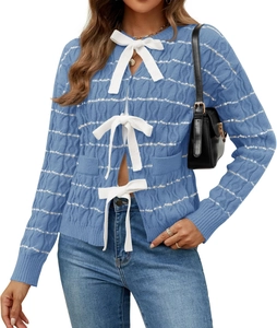 Detail of blue cable knit cardigan featuring white bow tie closure and striped texture