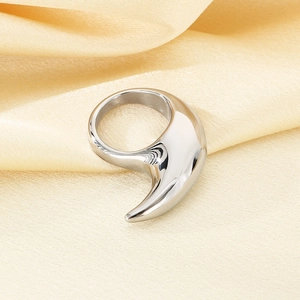 Macro-detail van een zilveren halve maan ring op een elegante beige zijden ondergrond