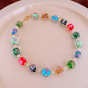 Macro view of colorful beaded necklace with floral patterns and golden lobster clasp