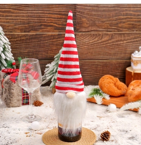 Close-up of Christmas gnome bottle cover with red striped hat and soft white beard
