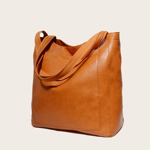 Gros plan sur un sac cabas marron avec poche frontale et bretelles en toile robuste