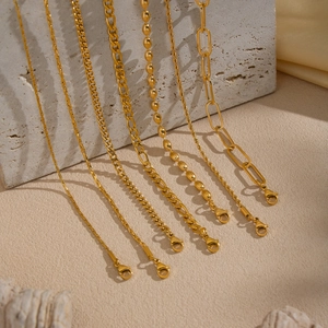 Macro shot of six gold-plated chain styles including Cuban and Figaro with lobster clasps
