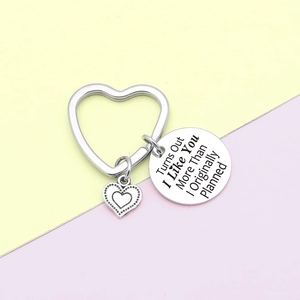 Close-up of heart-shaped stainless steel keychain with engraved romantic quote