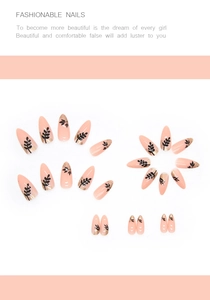Detail of almond-shaped nails with black leaf patterns and gold foil on nude base