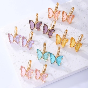 Close-up of six pairs of colorful transparent butterfly earrings with gold metal accents
