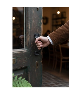 Close-up of vintage cast iron door handle mounted on an antique green wooden door