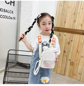 Girl wearing a white rabbit ear backpack with colorful sequins and floral straps
