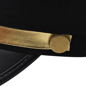 Détail d'une casquette plate noire avec ruban doré métallique et visière en cuir