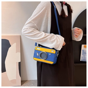 Detail of creative camera-shaped crossbody bag in blue and yellow with mock lens