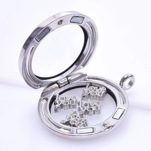 Macro shot of silver metal locket opened to reveal floating love you letter charms