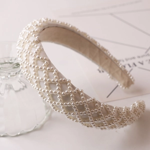 Detail showing the white satin padded headband with grid pattern faux pearl embellishment