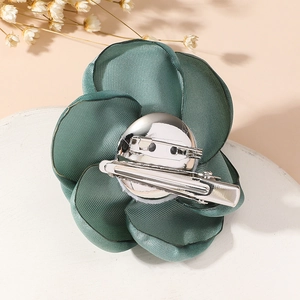 Detailed back view of vintage green fabric rose brooch with dual metal pin and clip