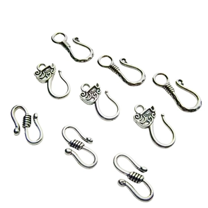 Silver alloy S-shaped jewelry hooks with vintage twisted textures on white background