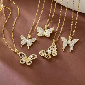 Detailed macro view of gold butterfly necklaces with pearls and sparkling zircons