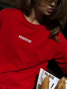 Dettaglio della t-shirt in cotone rosso con scritta assertive e stile street parigino