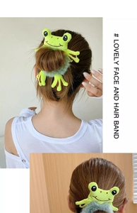 Detail view of the plush green frog hair tie used on high bun and ponytail styles