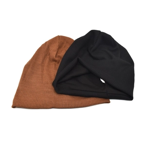 Detail showing waffle-knit texture and inner lining of brown and black beanies