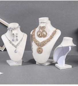 Detail view of crystal bridal necklace and earrings set on white velvet mannequin stand
