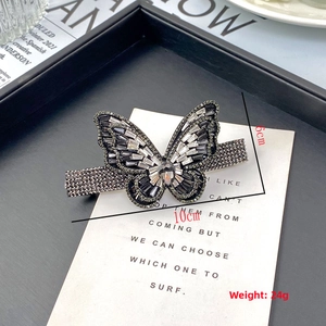 Detailed close-up of butterfly hair clip with sparkling black and white rhinestones