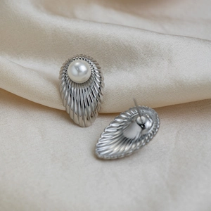 Detail view of silver French vintage shell stud earrings with white pearl and ribbed texture