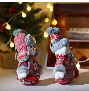 Vue détaillée de bonshommes de neige en peluche rouge et gris avec un éclairage de fête
