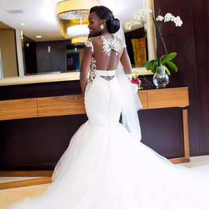 Elegant white mermaid wedding dress with lace open back and long train detail